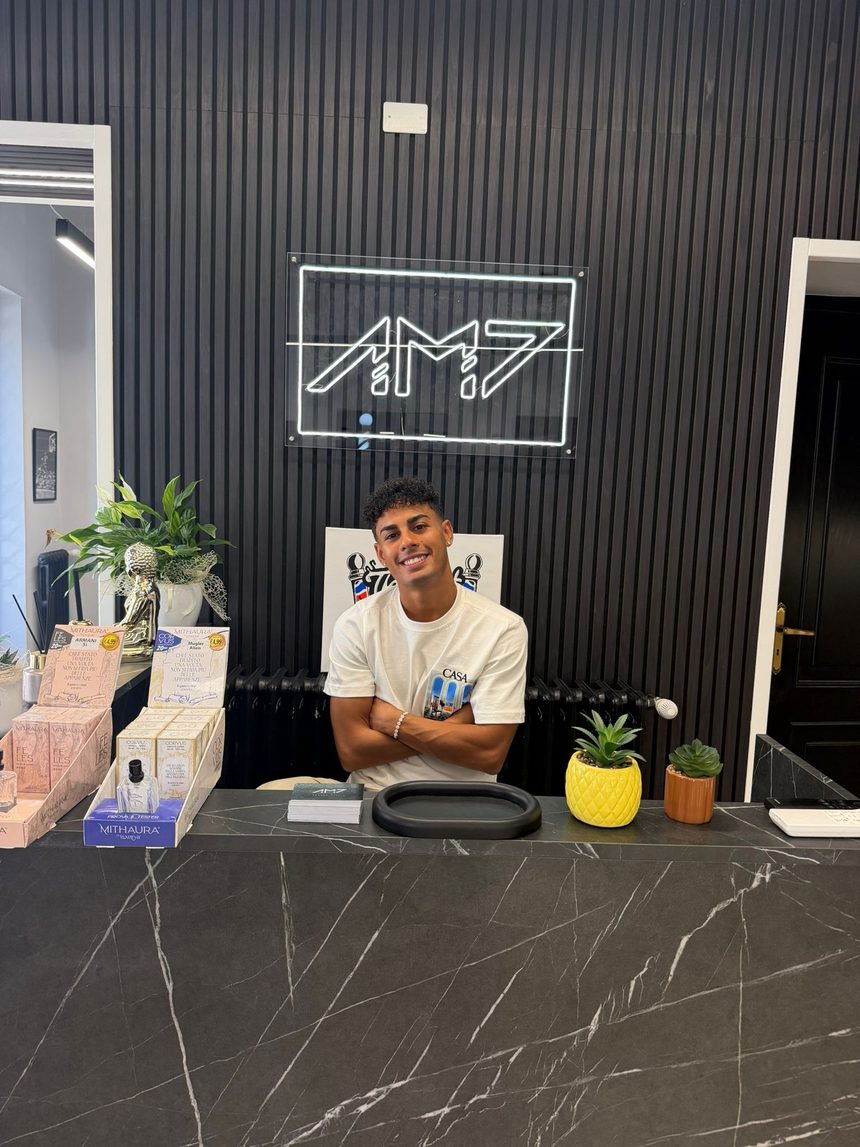 Oualid Ahmed, titolare di AM7 Barber, al bancone dello studio
