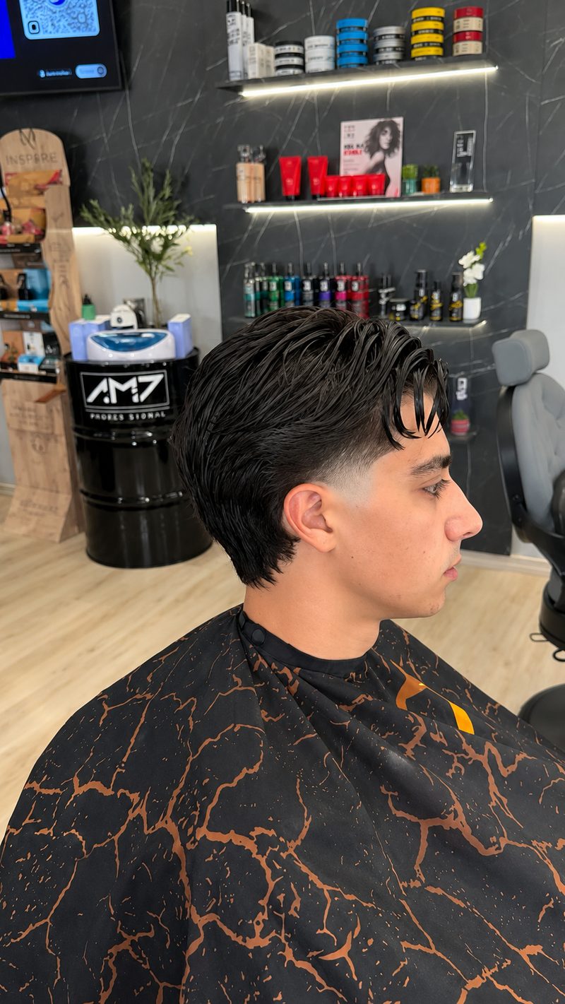 Taglio mosso con volume sulla sommità e sfumatura bassa realizzato da AM7 Barber
