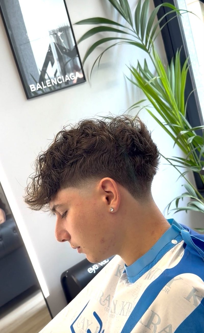 Taglio con riga disegnata a rasoio e sfumatura alta realizzato da AM7 Barber